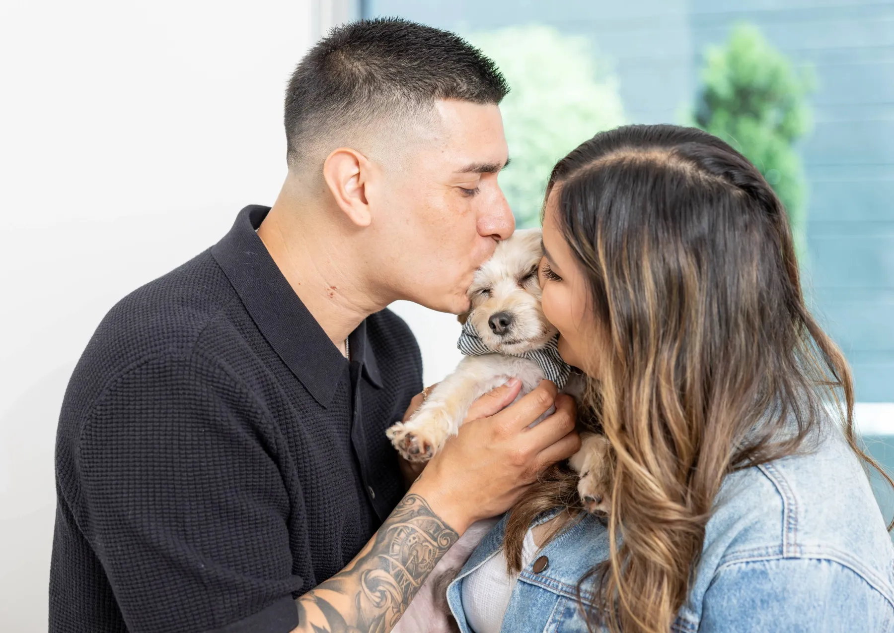 a man and a woman hugging their dog