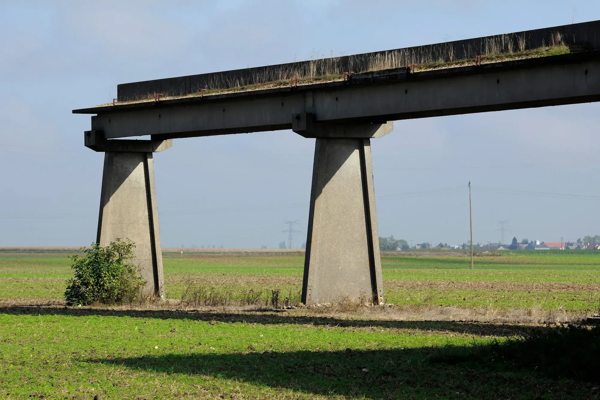 abandoned, half-finished hovertrain rail in a rural field in France.