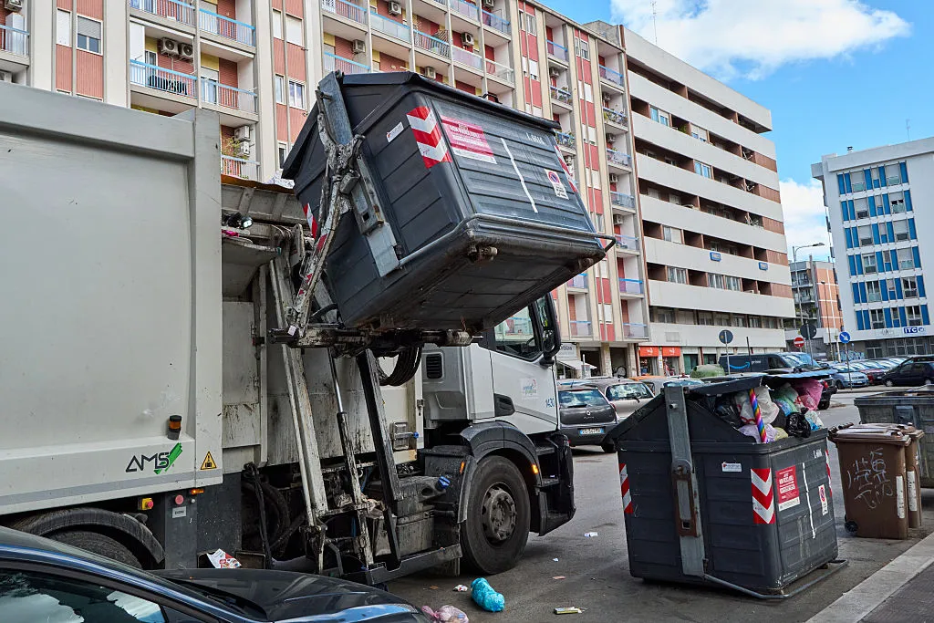 A garbage truck collects unsorted urban waste. The editorial image shows a garbage truck during the automated emptying of a bin containing unsorted municipal solid waste. The photo highlights the waste collection process in urban areas and the importance of efficient waste management systems to maintain city cleanliness and environmental sustainability in Bari, Italy, on October 8, 2025. (Photo by Matteo Della Torre/NurPhoto via Getty Images)