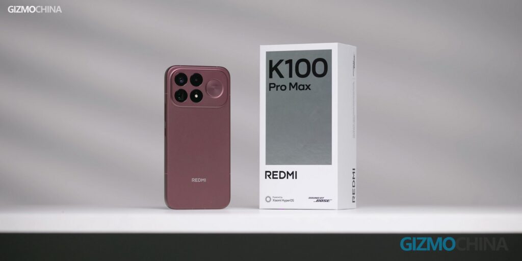 Redmi K100 Pro Max smartphone standing next to its white retail product box.